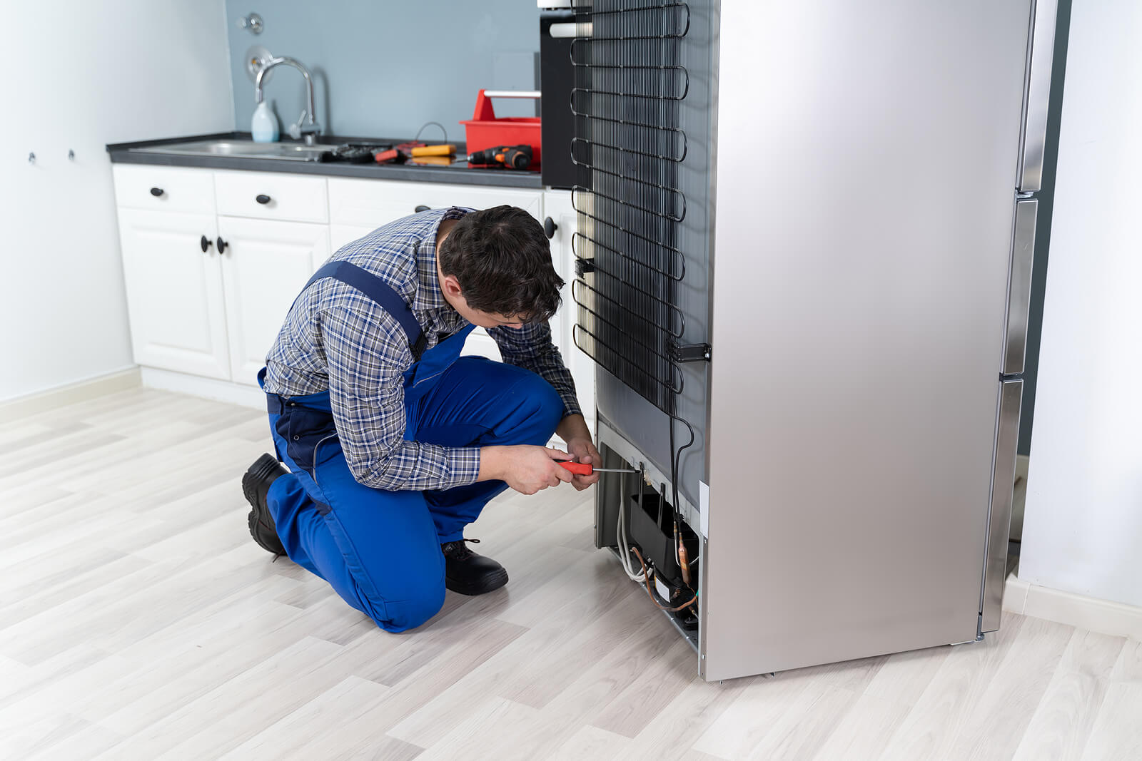 male worker repairing freezer