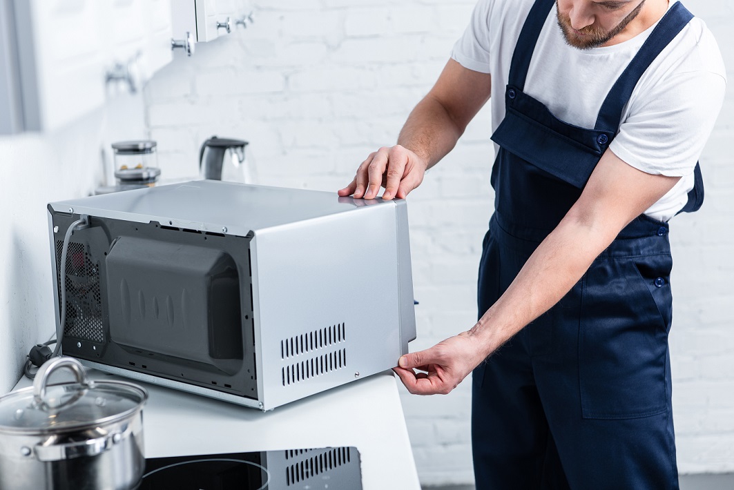man repairing microwave